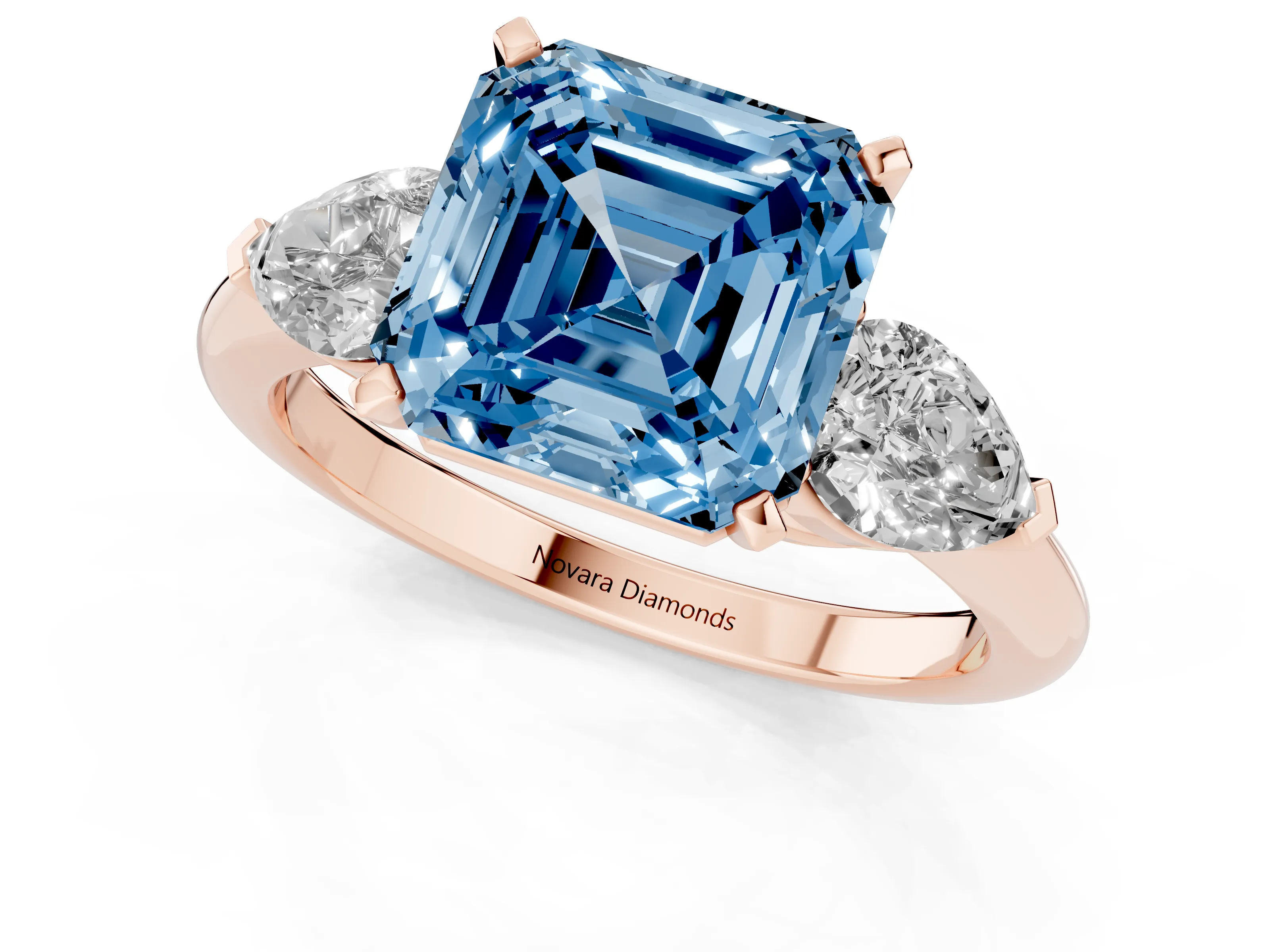 Fancy Blue Three-Stone Asscher Cut Diamond Ring Set in Rose gold with Pear Side Stones and Prong Setting